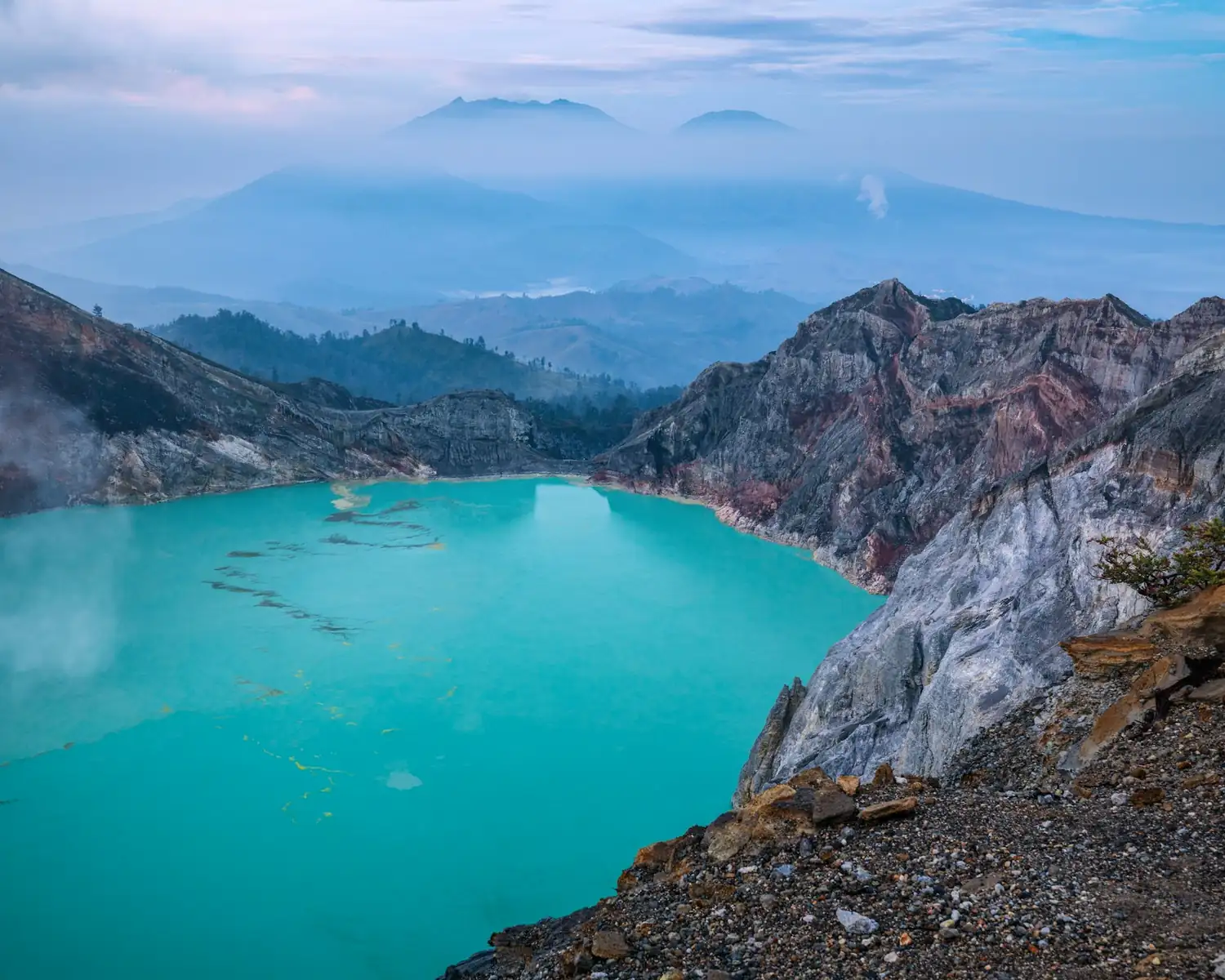 Turquoise crater lake of Kawah Ijen seen from the rim under a clear sky