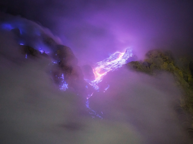 Blue fire glowing inside the Ijen crater at night