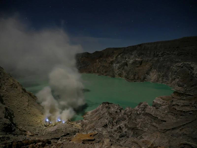 Blue fire glowing in the Ijen crater at dusk
