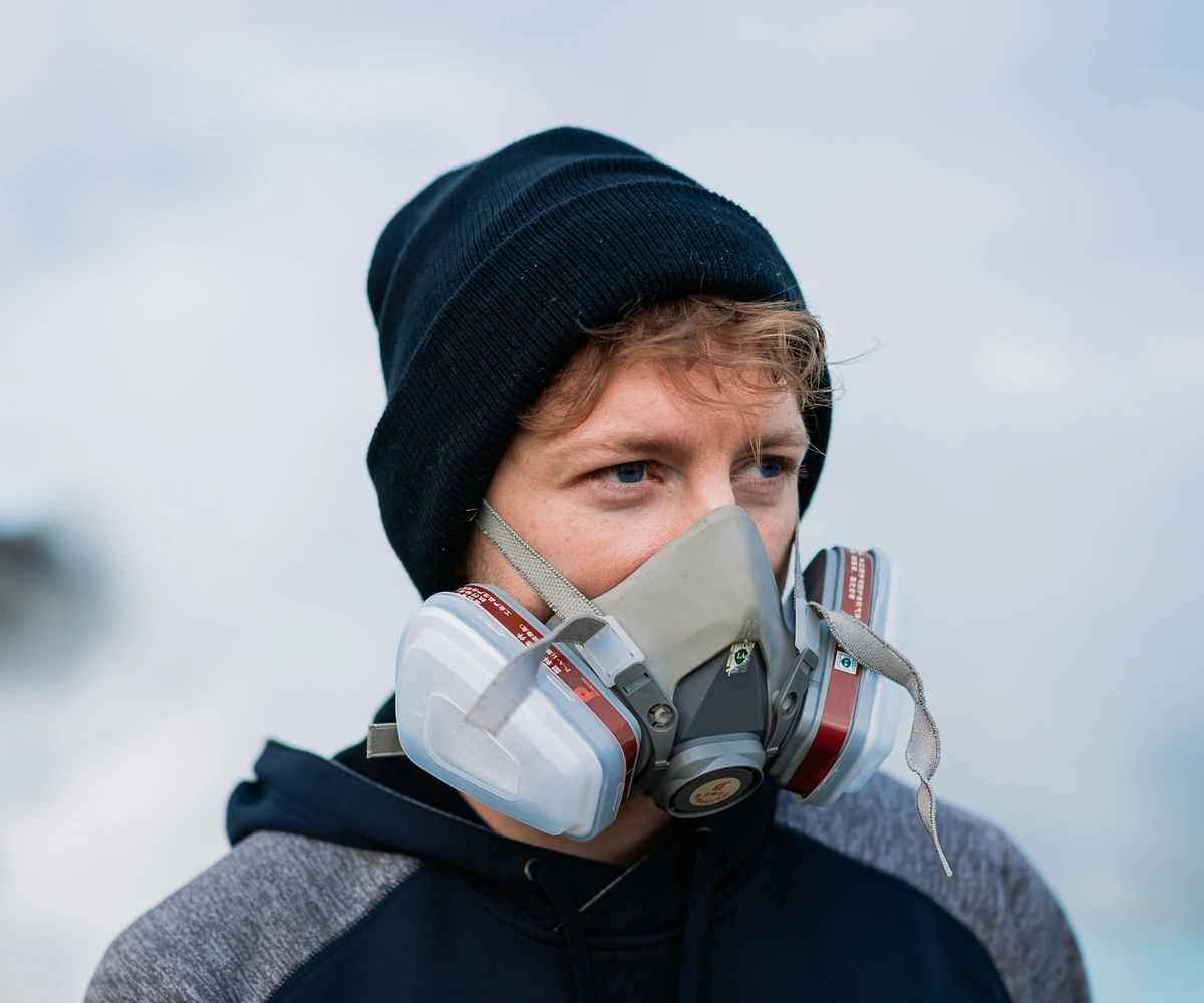 Hiker wearing a gas mask inside the crater
