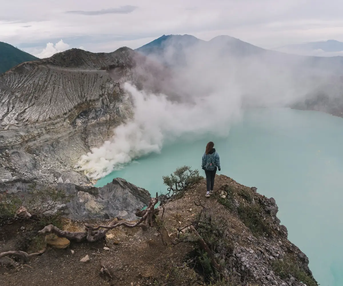 A lone traveller standing on the Kawah Ijen crater rim