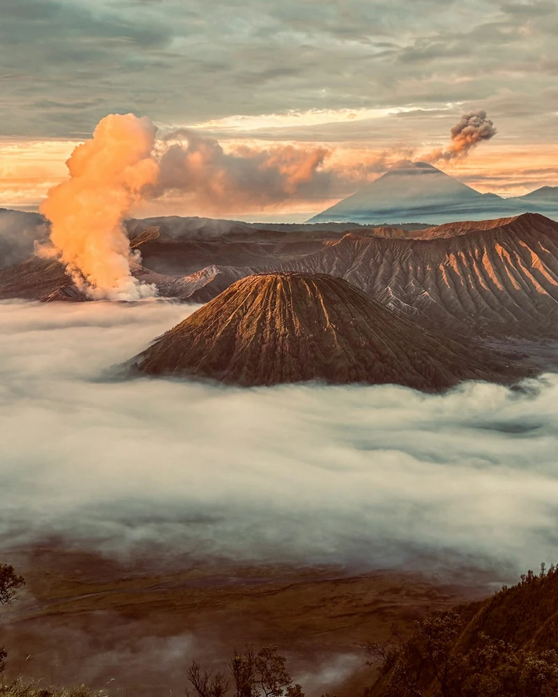 Mount Bromo caldera at sunrise above a sea of clouds