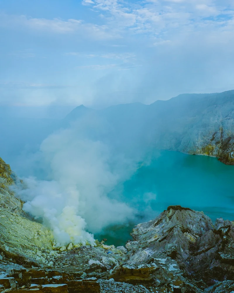 Kawah Ijen crater lake with steam rising from the sulfur vents